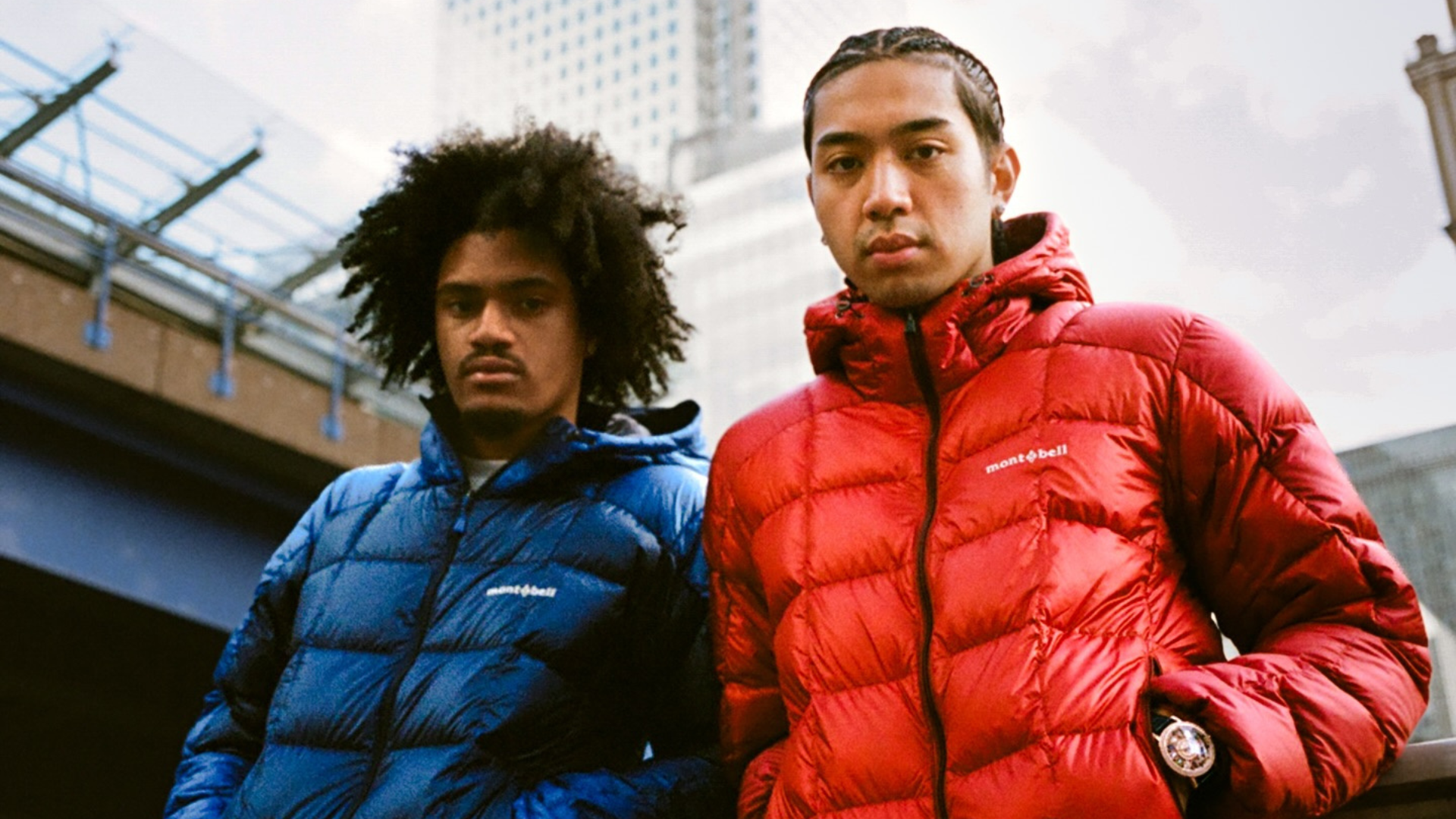 Two people wearing puffer jackets, one blue and one red, standing outdoors.