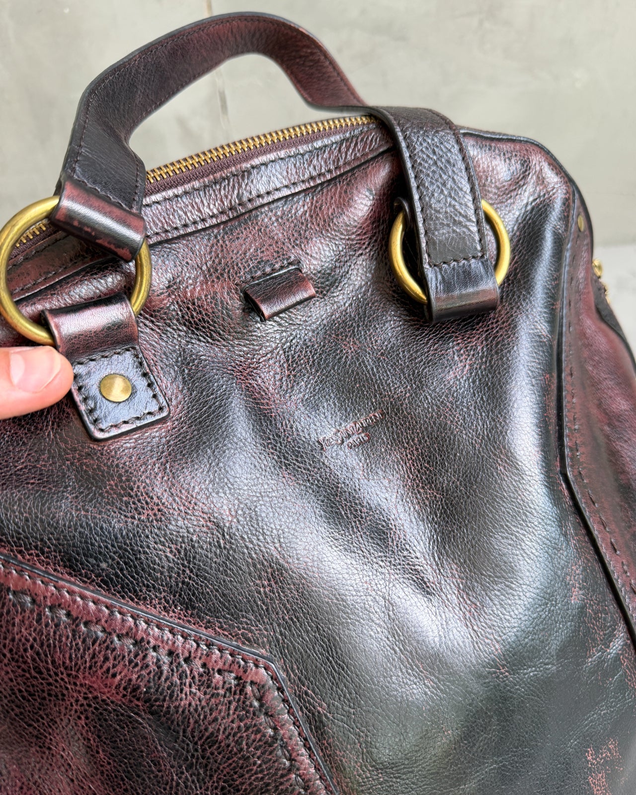 Yves Saint Laurent Leather Muse Bag-on a concrete background