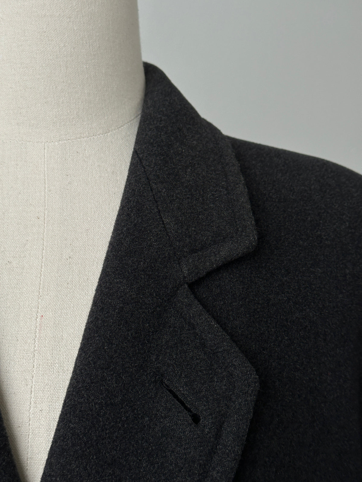 Vintage 1990s wool cashmere high neck belted coat displayed on a hanger, showcasing its classic design and rich texture.