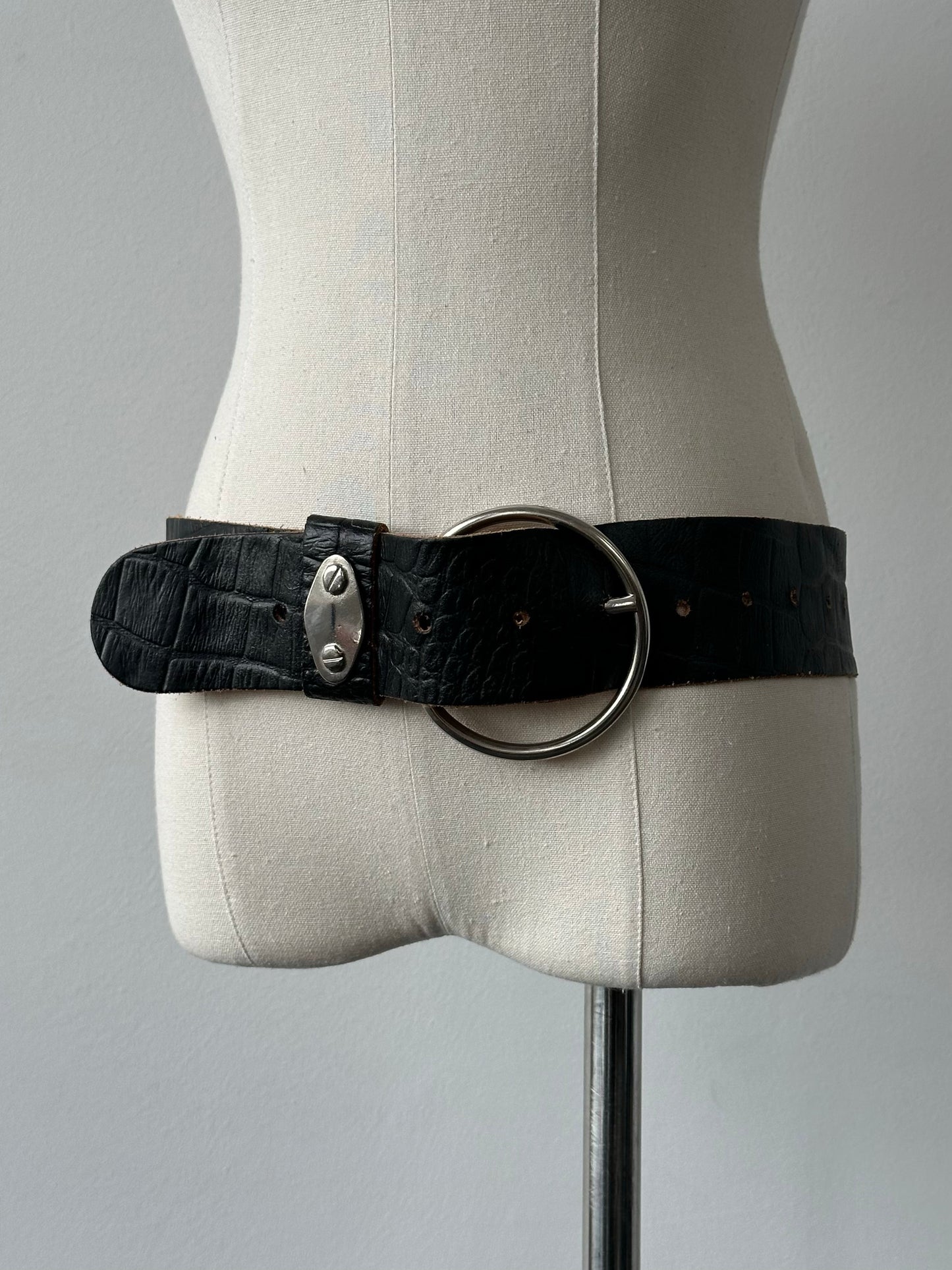 Vintage 1990s circular leather chunky belt showing textured brown leather and wide circular buckle, vintage style accessory.