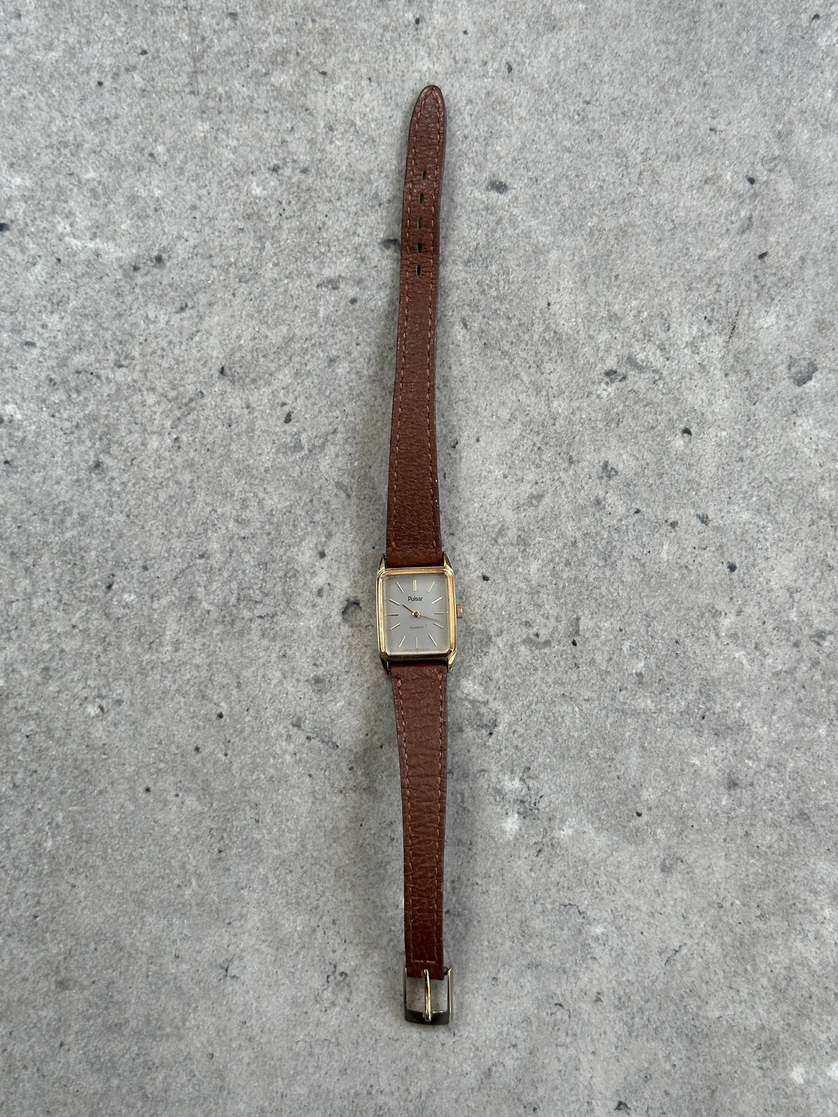 Vintage Pulsar 1980s gold-tone leather watch with round dial and classic design, showcasing a vintage timepiece style.