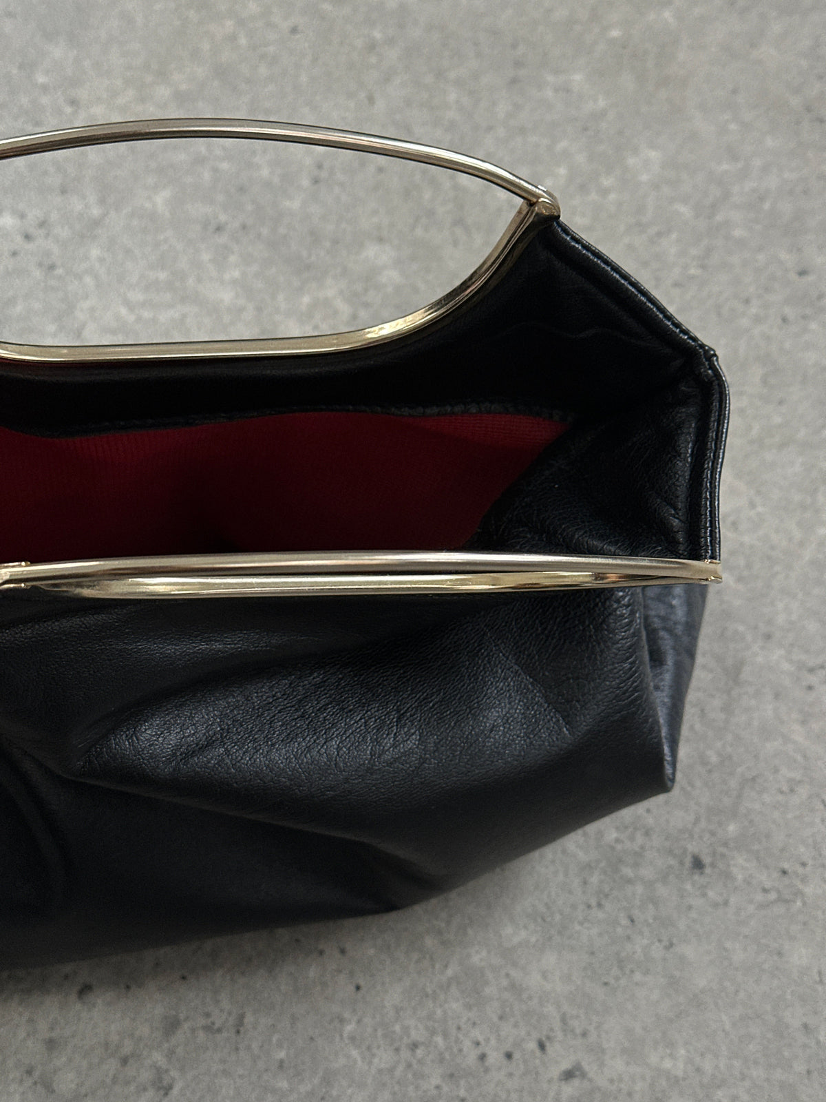 Vintage 1990s leather handbag with classic design, featuring a structured shape and vintage brand details.