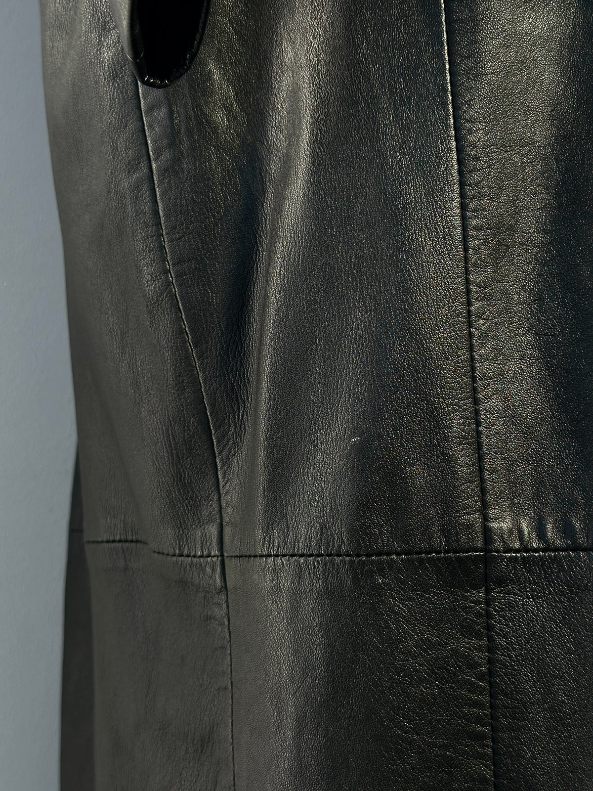 Vintage 1990s leather trench coat, floor length, in size small, displayed on a hanger. Classic and stylish vintage outerwear.