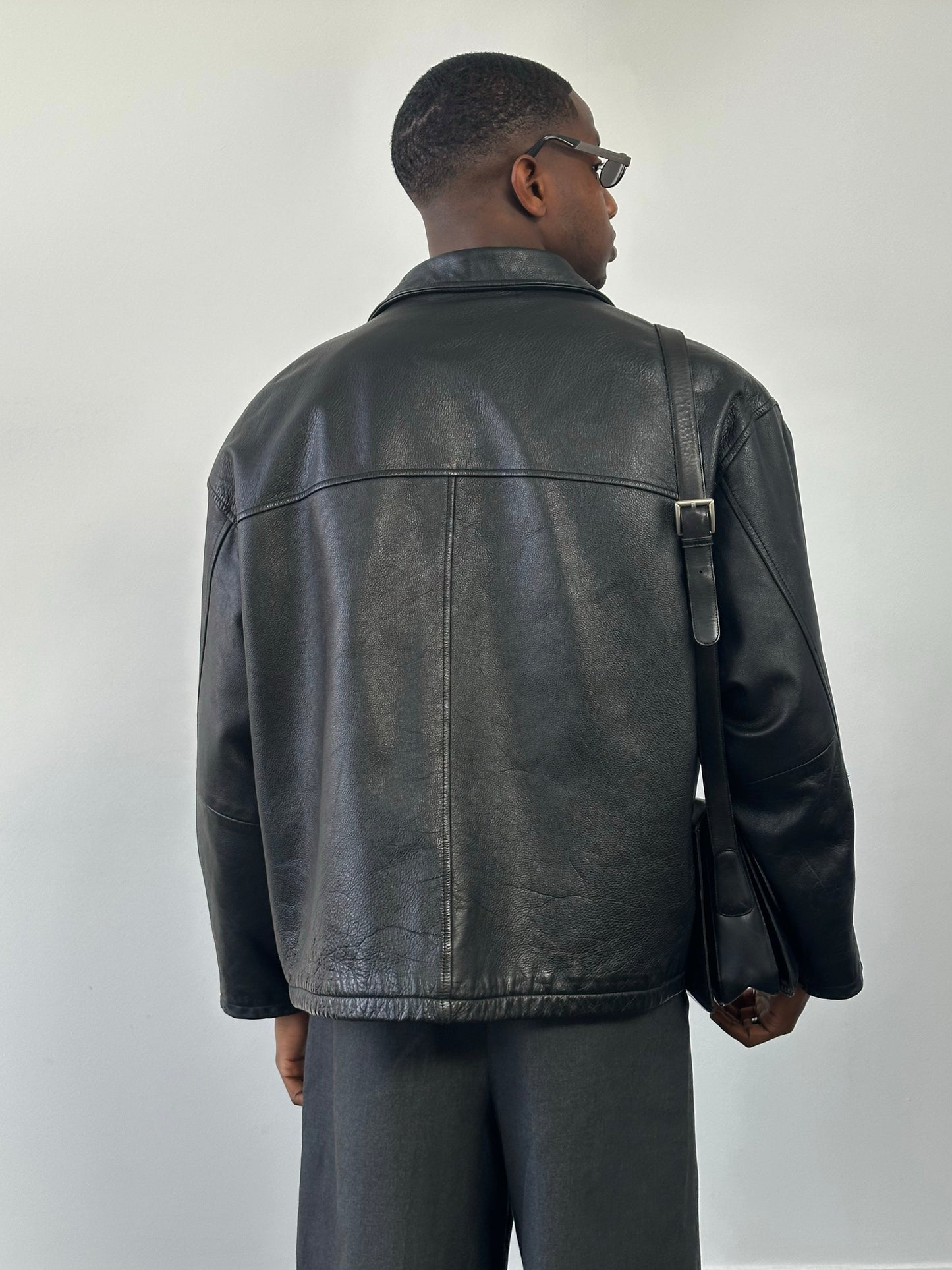 Vintage 1990s heavyweight leather jacket in black, featuring a minimal design and XXL size, with classic leather texture and details.