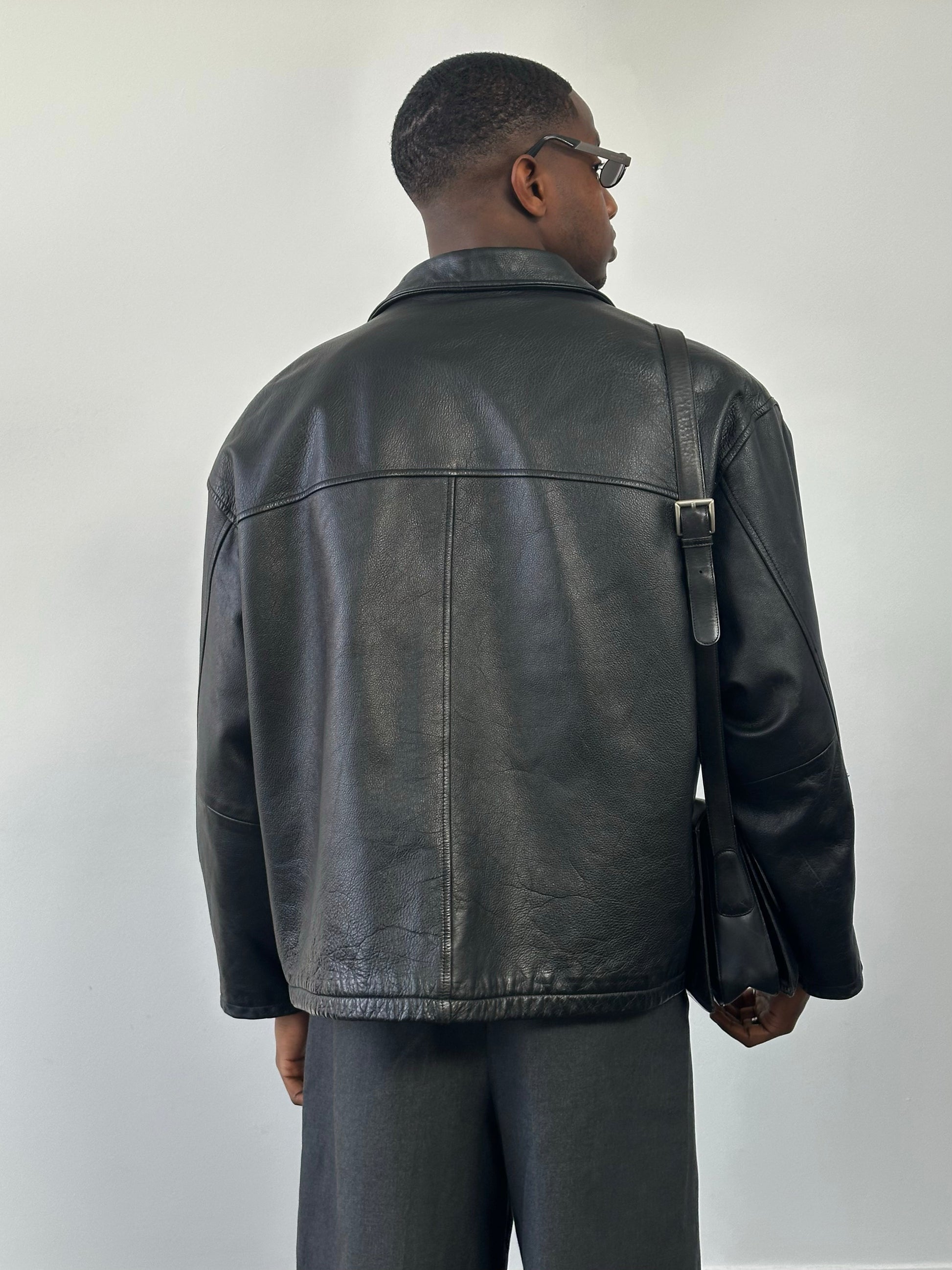 Vintage 1990s heavyweight leather jacket in black, featuring a minimal design and XXL size, with classic leather texture and details.