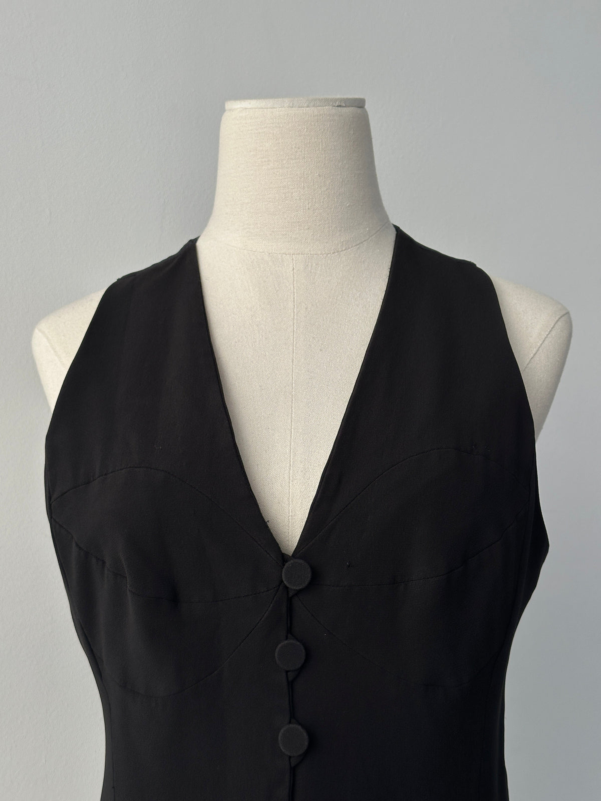 Emporio Armani 1990s fitted tailored single-button waistcoat in dark fabric, front view showing sleek design and classic style.