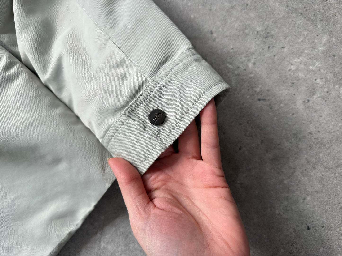 Gianfranco Ferre 1990s showerproof minimal jacket in size L, showcasing a sleek, lightweight design with a smooth fabric finish.