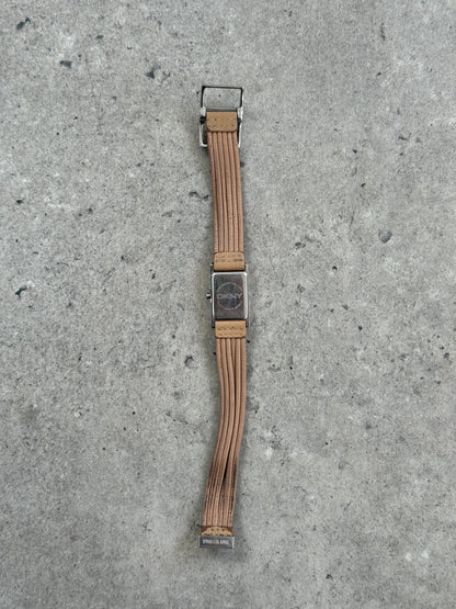 Donna Karran DKNY 2000s leather rectangular quartz watch with silver-tone dial and black leather strap, close-up view.