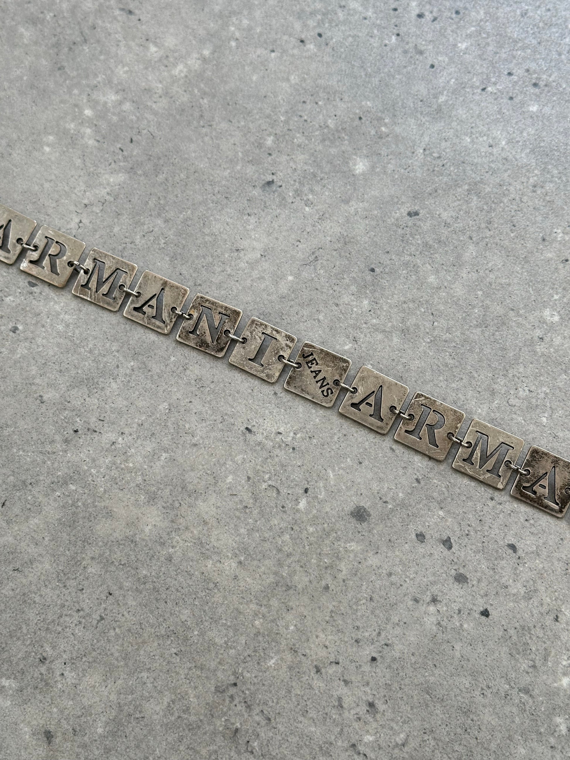 Armani Jeans 1990s monogram chain belt, one size, featuring gold-tone chain and monogram details, on a neutral background.