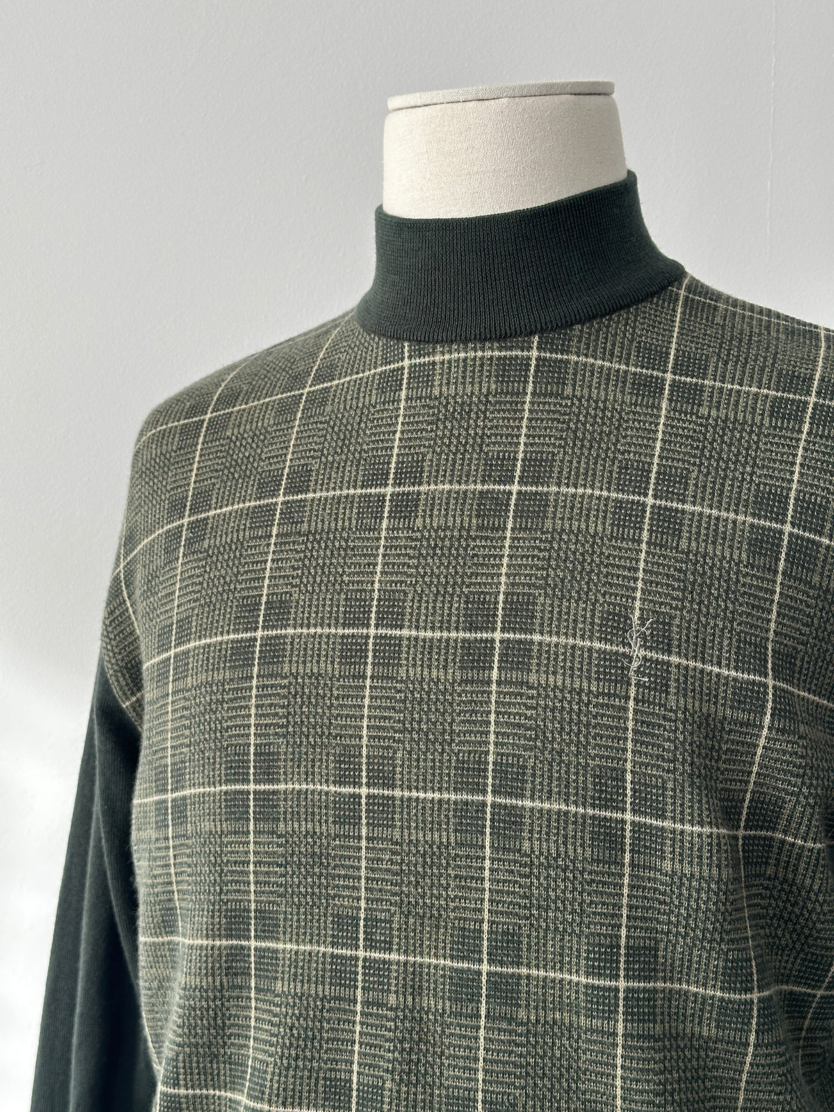 Yves Saint Laurent 1990s pure wool check high-neck jumper in black, white, and red, featuring a classic plaid pattern and high collar.