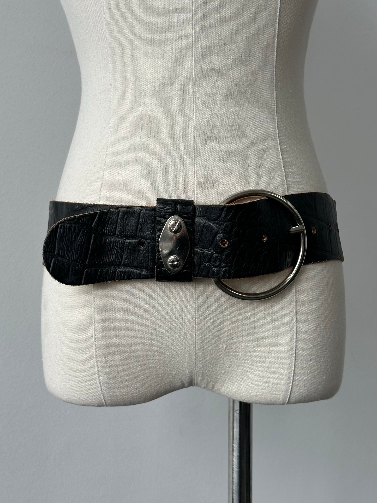Vintage 1990s circular leather chunky belt with bold design, featuring a large round buckle and distressed leather finish.