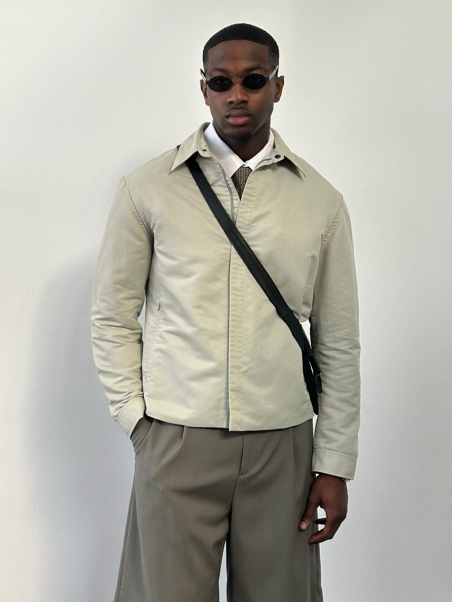 Gianfranco Ferre 1990s showerproof minimal jacket in size L, shown in a neutral color, with sleek, simple design and waterproof material.