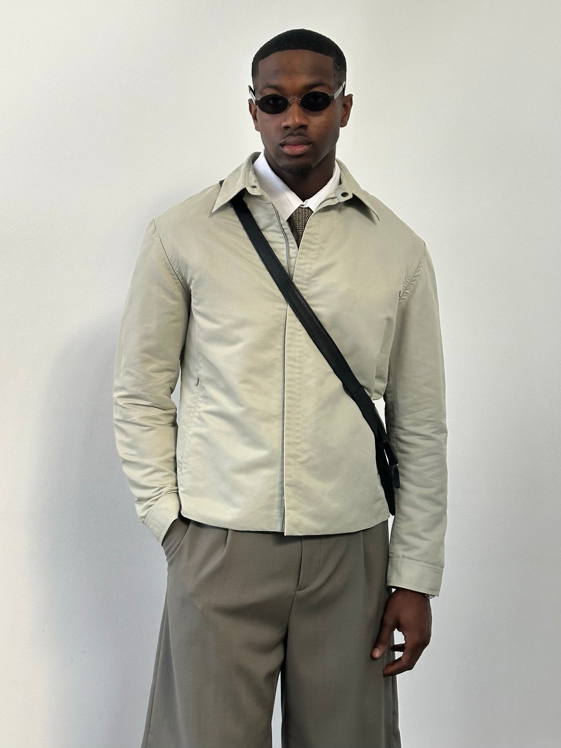 Gianfranco Ferre 1990s showerproof minimal jacket in size L, shown in a neutral color, with sleek, simple design and waterproof material.