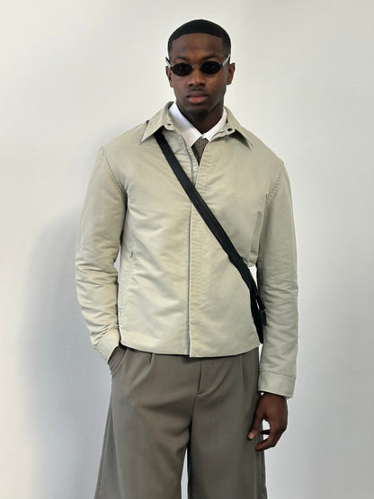 Gianfranco Ferre 1990s showerproof minimal jacket in size L, shown in a neutral color, with sleek, simple design and waterproof material.