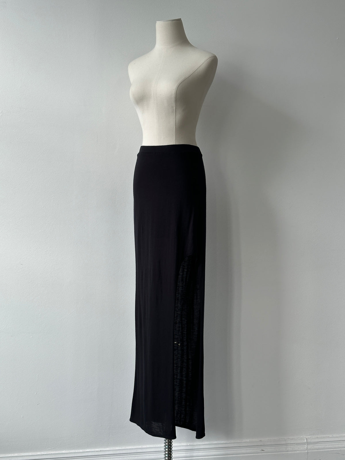 Helmut Lang 2000s side split maxi skirt in black, flowing fabric, high waist, styled with urban fashion elements.