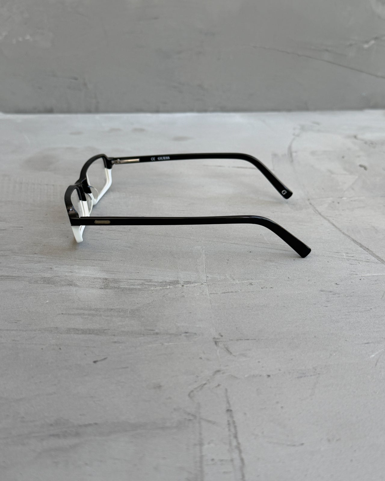 Guess Two Tone Black and White Clear Lens Glasses-on a concrete background