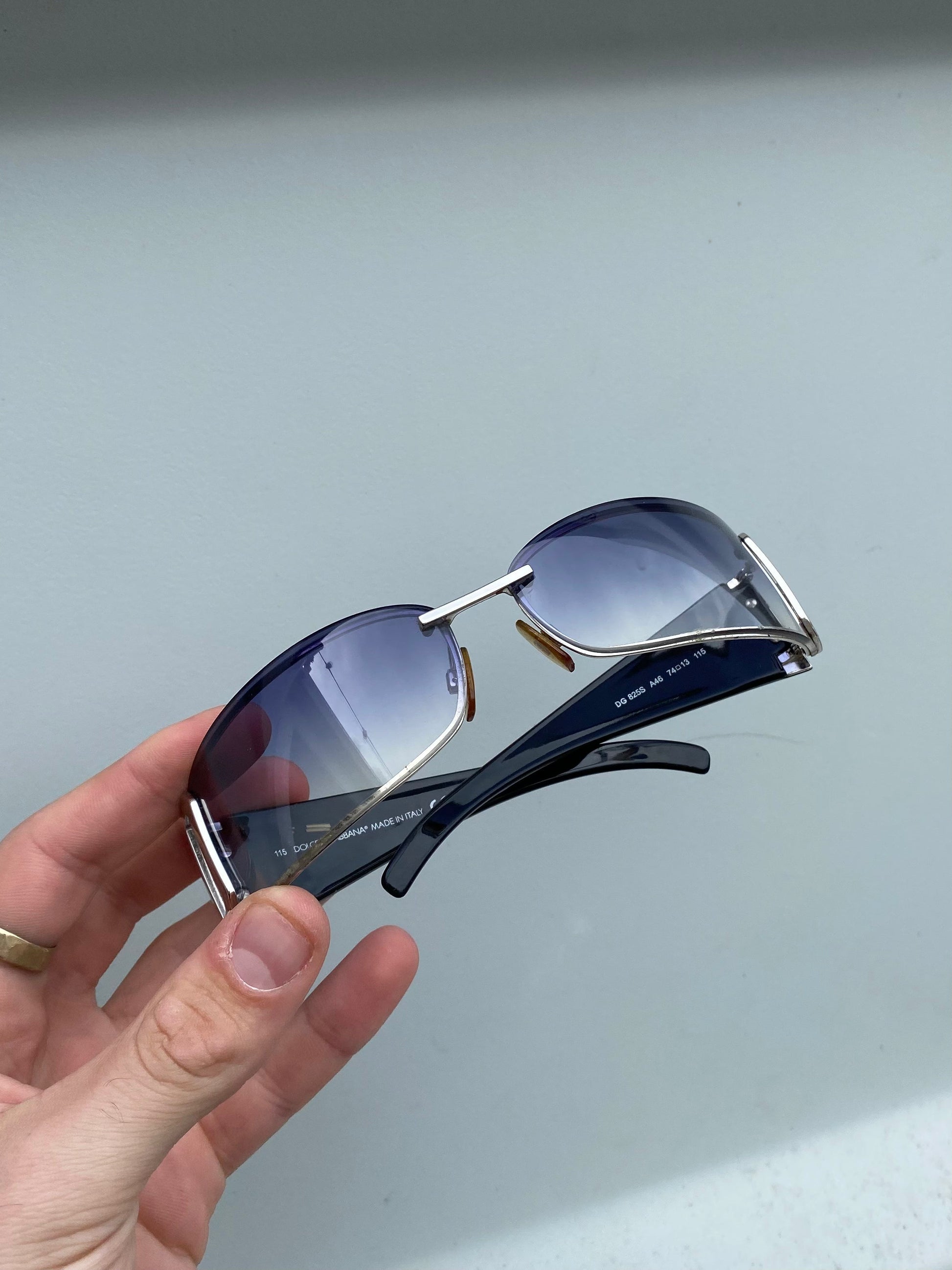 Dolce & Gabbana shield sunglasses with dark tinted lenses and bold black frame, stylish eyewear for sun protection.