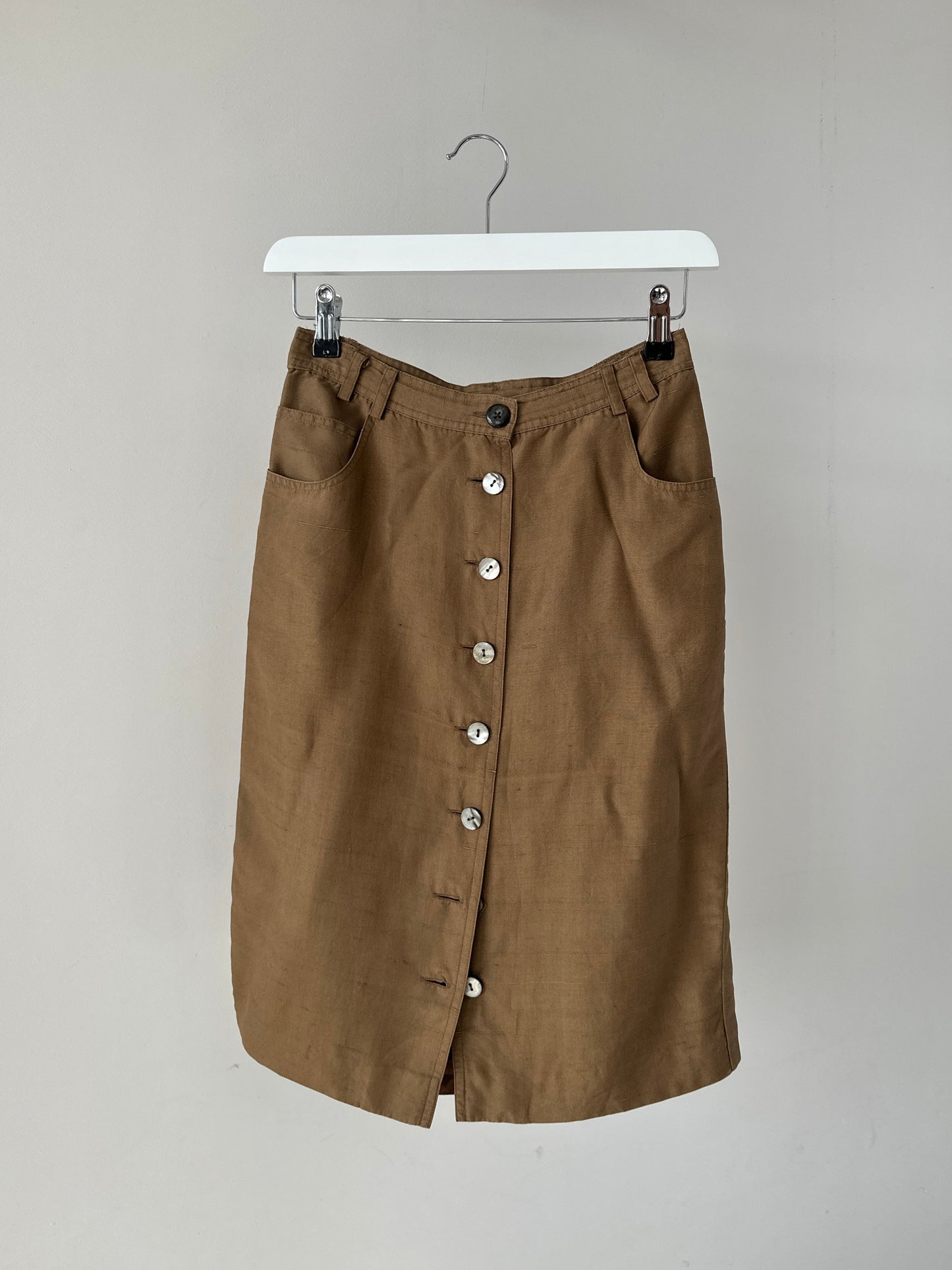 Jaeger pure silk button-down midi skirt in W24, featuring a sleek design with buttons down the front and a smooth silk texture.