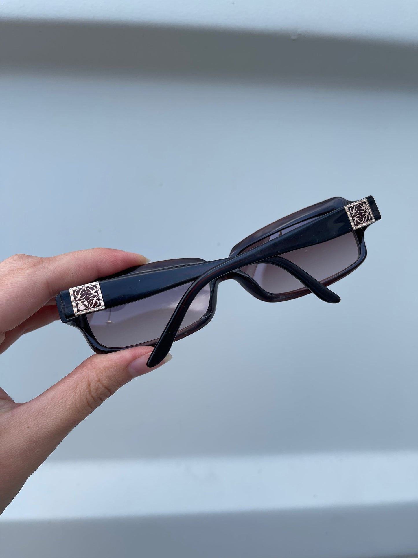 Loewe rectangle sunglasses with black frames and dark tinted lenses, stylish and modern eyewear for sun protection.