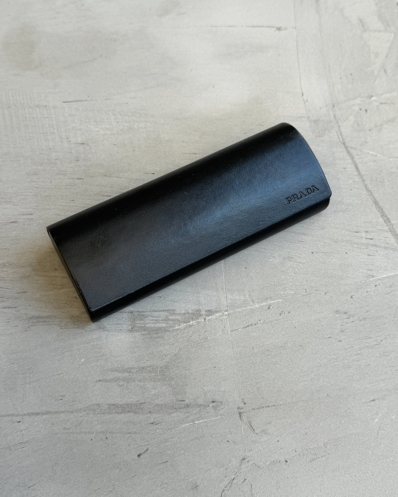Prada Clear Lens Brown Frame Glasses-on a concrete background
