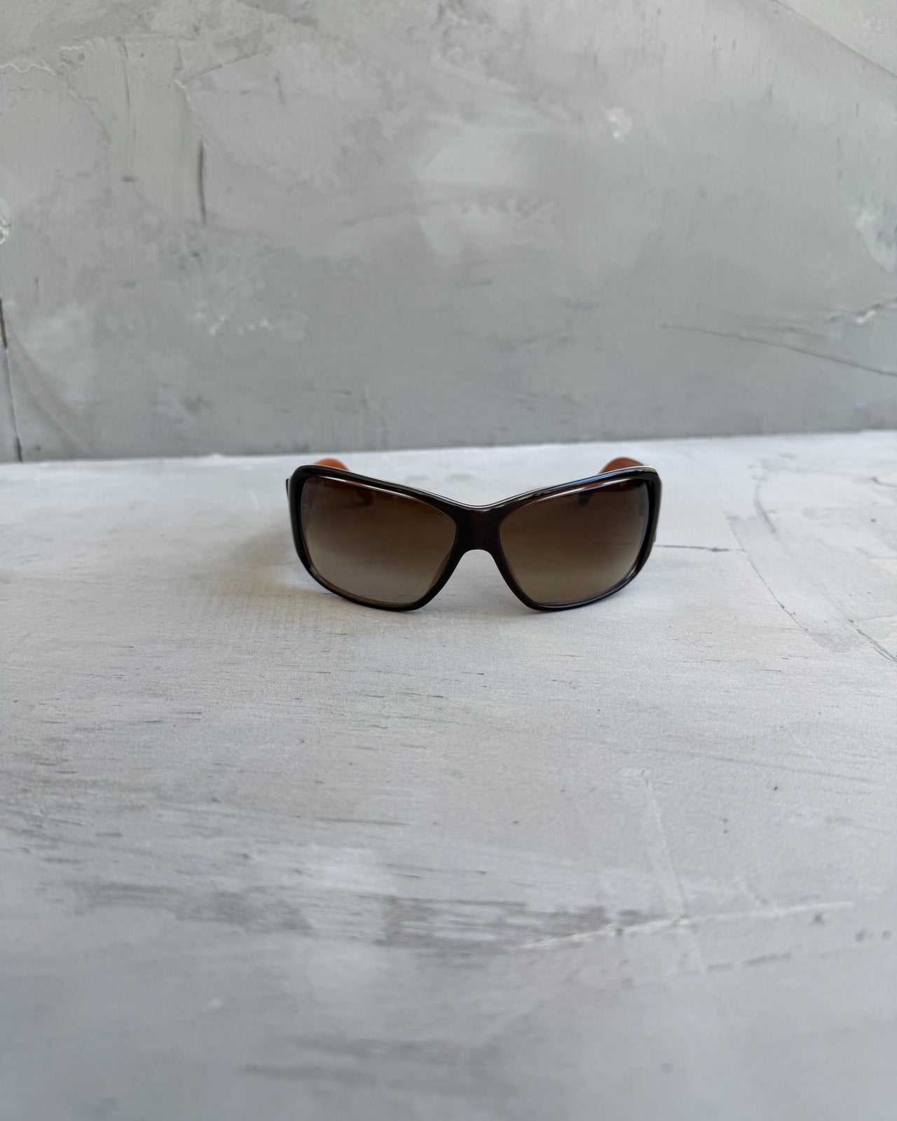 Prada Brown Sunglasses-on a concrete background