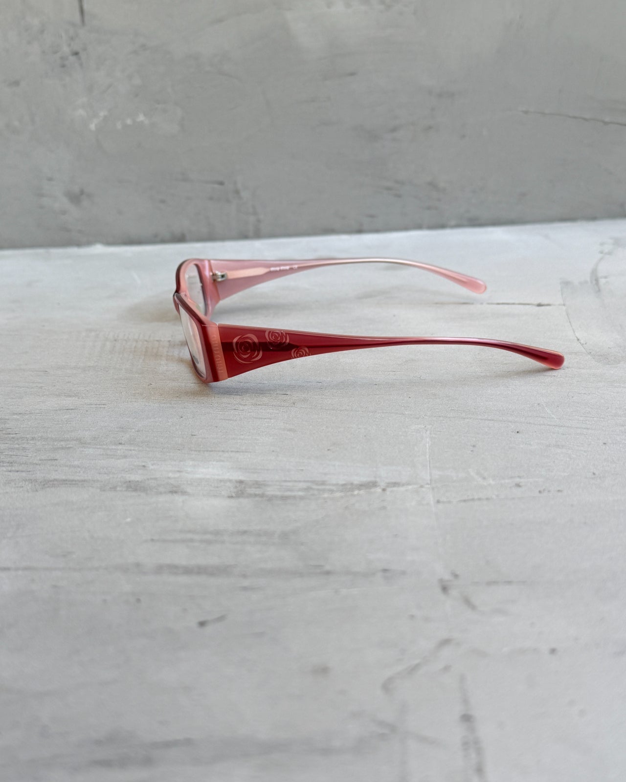 Miu Miu Pink Clear Lens Glasses-on a concrete background